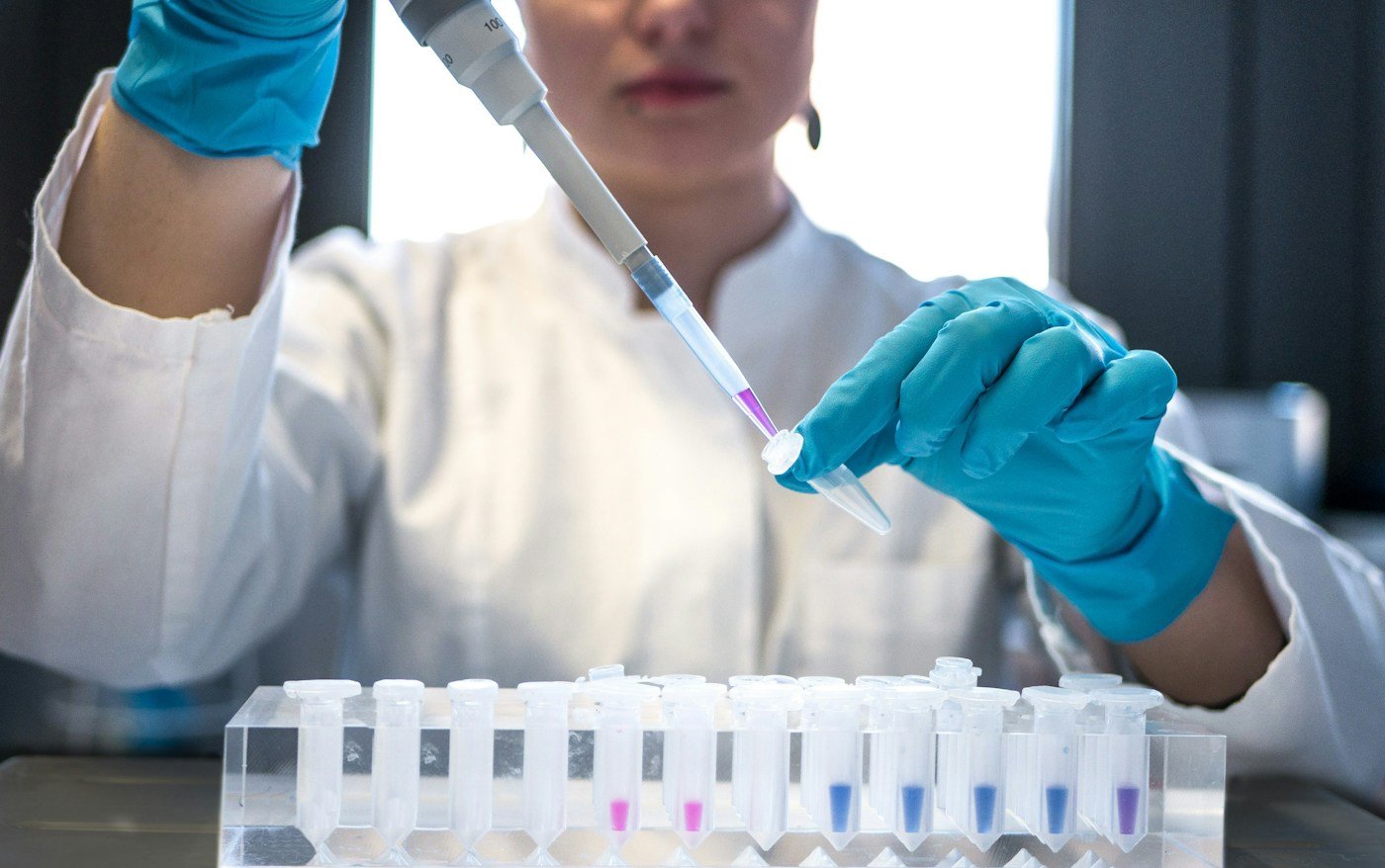 A scientist pipetting samples into test tubes in a laboratory